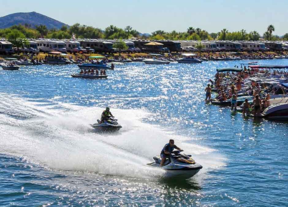 A group of individuals riding jet skis on a vibrant blue water surface, enjoying a sunny day outdoors